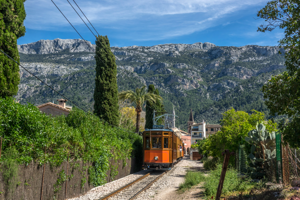 Tranvía de Sóller con las montañas de la Serra de Tramuntana como telón de fondo.